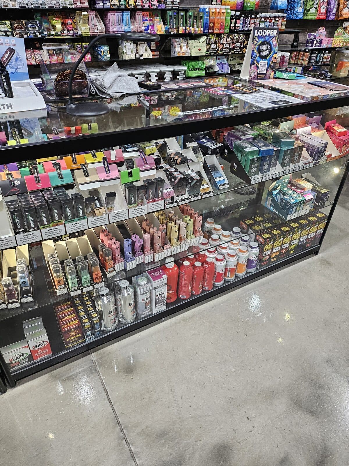 Display case of disposables, devices, and e-juice at the 3 Heads Smoke Shop vape superstore in Elgin